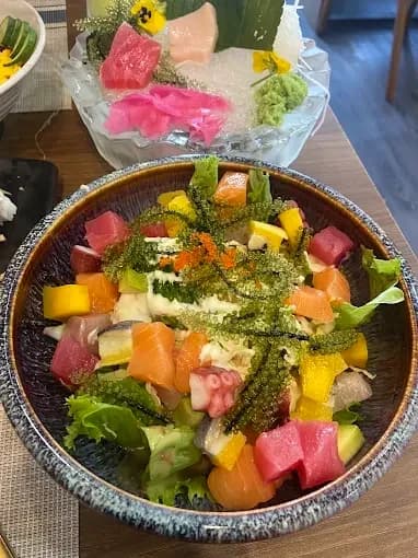 Bowl of diced fish, colourful toppings and greens