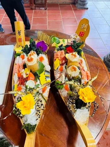 Two wooden boats filled with sushi and sashimi