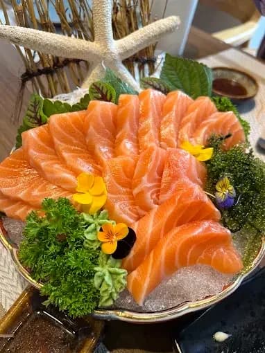 Salmon slices arranged on a platter with flowers
